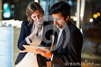 Businessman discussing with colleague over digital tablet Stock Photo