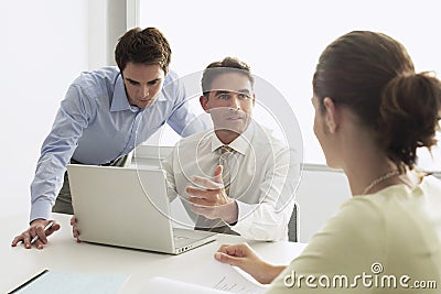 Businessman Discussing With Colleagues At Desk Stock Photo