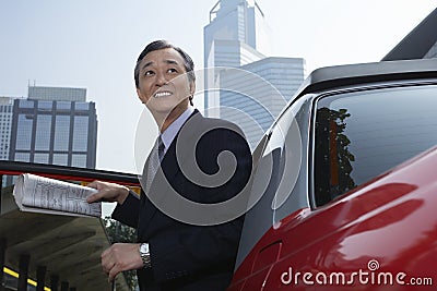 Businessman Disembarking From Cab Stock Photo