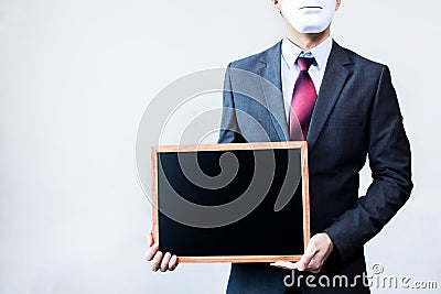 Businessman in disguise mask holding blackboard sign Stock Photo