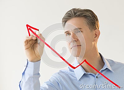 Businessman Drawing Arrow Moving Upwards On Transparent Board Stock Photo