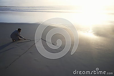 Businessman Drawing Arrow In Sand Stock Photo