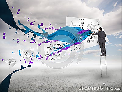 Businessman drawing on a paper next to paints splash Stock Photo