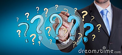 Businessman drawing question marks with a pen Stock Photo