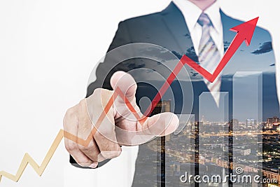 Businessman drawing a rising up arrow by finger, representing business growth Stock Photo