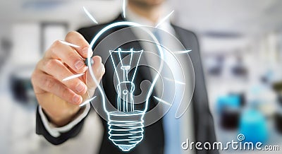 Businessman drawing a sketch lightbulb with a pen Stock Photo