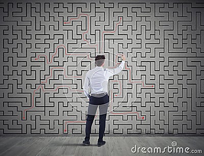 Businessman draws the solution of a labyrinth. Concept of problem solving Stock Photo