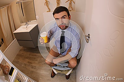 Businessman drinking coffee for constipation relief Stock Photo