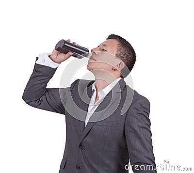 Businessman drinking water while standing against white Stock Photo