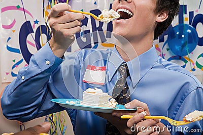 Businessman eating party cake Stock Photo