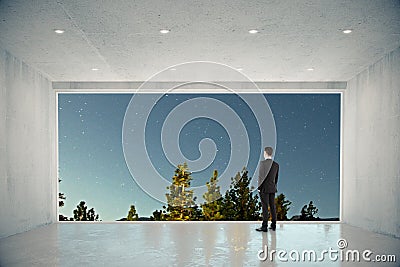Businessman in empty concrete room with big window with nature c Stock Photo