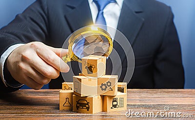 A businessman examines boxes goods with magnifying glass. Market structure research, find unoccupied target consumer niches, Stock Photo