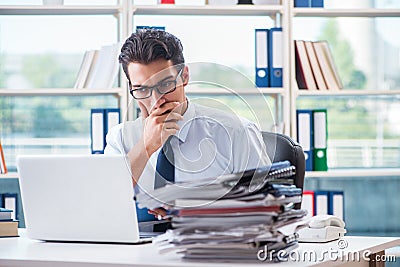 The businessman with excessive work paperwork working in office Stock Photo