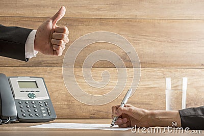 Businessman expressing his approval by making a thumbs up gestur Stock Photo