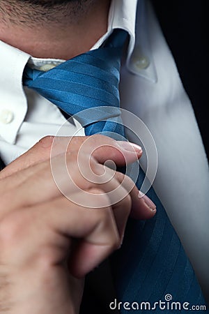 Businessman without face straightens tie himself. Isolated on b Stock Photo