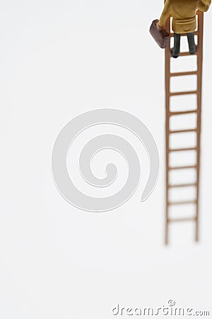 Businessman Figurine Climbing On Ladder Stock Photo