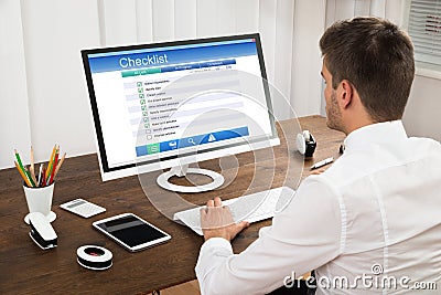 Businessman Filling Checklist Form On Computer Stock Photo