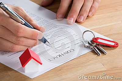 Businessman Filling Contract Form On Desk Stock Photo