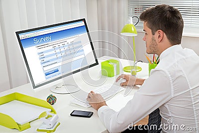 Businessman Filling Online Survey Form On Computer Stock Photo