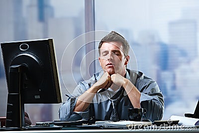 Businessman focusing on problems in office Stock Photo