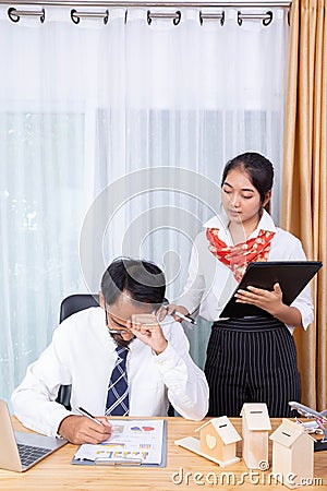 A businessman is frustrate on his business while his female assistance touch to cheer him up Stock Photo