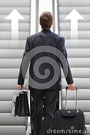 Businessman front escalator with arrows Stock Photo