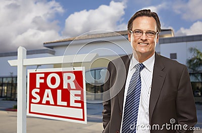 Businessman In Front of Office Building and For Sale Sign Stock Photo