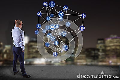Businessman in front of a wall with a business network connection displayed on a futuristic interface with technology icon - Stock Photo