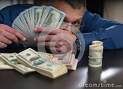 Businessman peering out from a handful of money Stock Photo