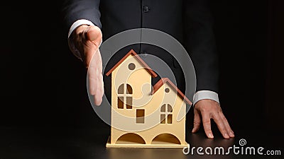 Businessman give handshake over a house model on a table Stock Photo