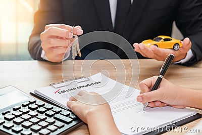 Businessman giving car key and customer signing loan agreement w Stock Photo