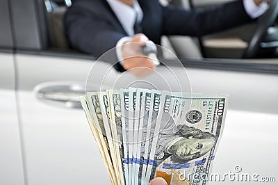 Businessman giving a car key exchanging with money Stock Photo