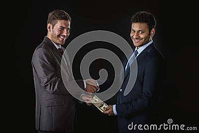 Businessman giving money and bribing business partner isolated on black Stock Photo