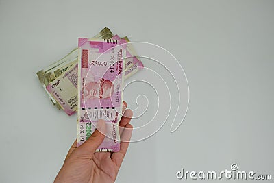 A businessman giving money in the form of Indian Rupees for services rendered as per a signed contract. 2000 and 500 rupee notes. Stock Photo