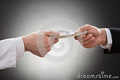 Businessman giving money to doctor Stock Photo