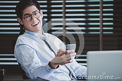 Businessman in glasses sitting at office desk with laptop Stock Photo