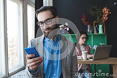 Businessman in glasses with smartphone over woman working on bac Stock Photo