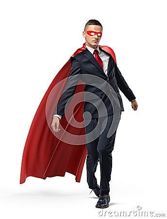 A businessman with glowing eyes wearing superman red cape and a mask walking unsteady on white background. Stock Photo