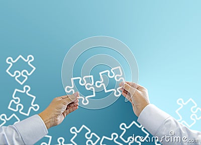 Businessman hand connecting neon light jigsaw puzzle Stock Photo