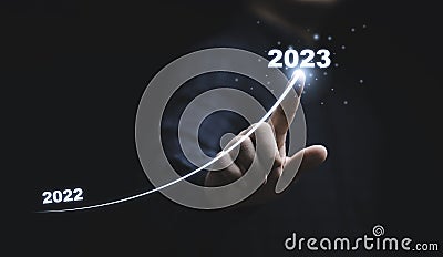 Businessman hand drawing for increasing arrow from 2022 to 2023 for preparation merry Christmas and happy new year concept Stock Photo