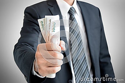 Businessman hand grabbing money, Thai Baht (THB) Stock Photo