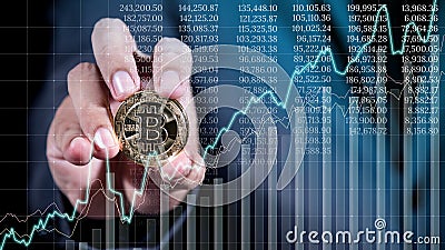 businessman hand holding crytocurrency bitcoin with business graph on screen Stock Photo