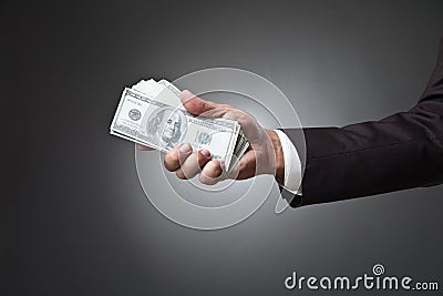 Businessman hand holding money on dark background Stock Photo