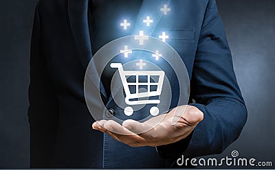 Businessman hand holding virtual trolley cart icons with plus sign symbol to add, plus or receive order.I ncrease volume of sales Stock Photo