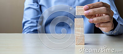 Businessman hand holding wooden cube with GOAL text on table background. success, strategy, solution and business concepts Stock Photo