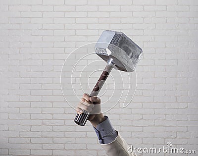 businessman hand holds hammer Thor Stock Photo