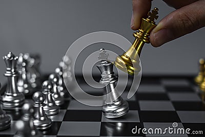 Businessman hand moving gold Chess King figure and Checkmate opponent during chessboard competition. Strategy, Success, management Stock Photo