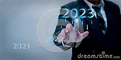 Businessman hand pointing virtual digital graphic 2023 year, preparing happy new year concept. Stock Photo