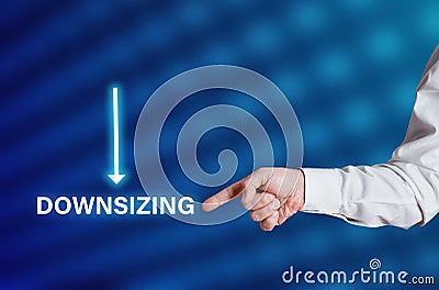 Businessman hand points to the word downsizing with downwards arrow icon Stock Photo