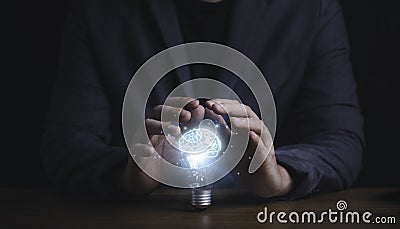 Businessman hand protecting with lightbulb with virtual brain glowing , patent and creative idea innovation concept Stock Photo